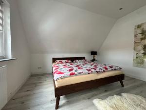 a bedroom with a bed with red flowers on it at Gemütlich wohnen in Brake in Bielefeld