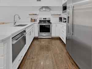 シーグローブ・ビーチにあるThe Night Cap by 30A Escapesの白いキャビネットとステンレス製の電化製品を備えたキッチン