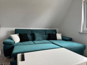 a blue couch with pillows in a living room at Gemütlich wohnen in Brake in Bielefeld +1 photo