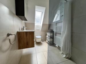a bathroom with a sink and a toilet and a window at Gemütlich wohnen in Brake in Bielefeld