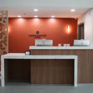 a lobby with a red wall and a reception desk at Candlewood Suites Houston Space Center - Webster in Webster
