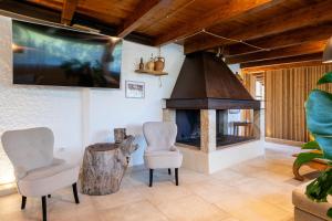 a living room with two chairs and a fireplace at Villa Sole Tra i Ginepri in Olbia