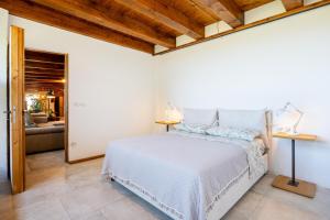 a bedroom with a white bed and a couch at Villa Sole Tra i Ginepri in Olbia +45 photos