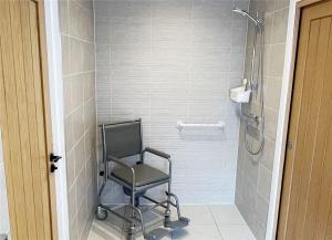 eine Dusche mit Stuhl im Bad in der Unterkunft Fully Accessible-Disabled Adapted-Hot Tub-Pets in Alcester + 9 Fotos