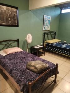 a bedroom with two beds and a fan at Monchita's Ensenada Baja, apartments for rent. in Ensenada