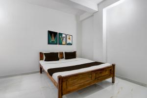 a bed in a room with white walls at Hotel O Shree Guest House in Khandagiri