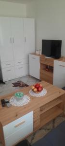a table in a kitchen with a bowl of apples on it at Studio apartman City Centre Rogatica in Rogatica