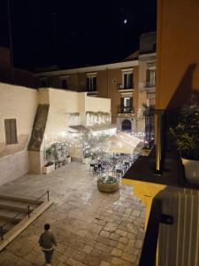 a person walking around a courtyard at night at La Dimora di Vittorio Emanuele II in Barletta