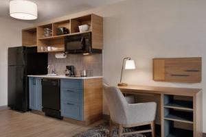 a small kitchen with a desk and a black refrigerator at Candlewood Suites Houston Space Center - Webster in Webster +36 photos