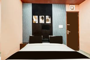 une chambre avec un grand lit et deux chaises dans l'établissement Hotel O Kashish Residency, à New Delhi