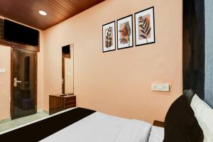 - une chambre avec un lit et trois photos sur le mur dans l'établissement Hotel O Kashish Residency, à New Delhi
