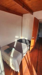 圣胡利安港Los cabos的铺有木地板的房间里的一张床