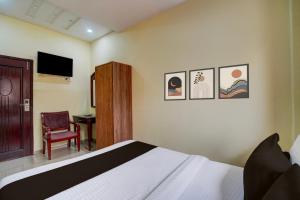 une chambre avec un lit, une chaise et une télévision dans l'établissement Hotel O Gold Coast, à Mumbai