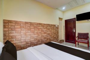 - une chambre avec un lit, une chaise et une télévision dans l'établissement Hotel O Gold Coast, à Mumbai