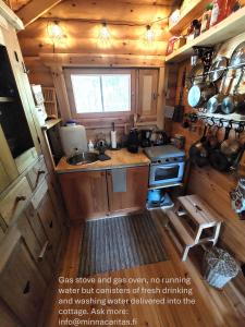 eine kleine Küche mit Spüle und Herd in der Unterkunft Arctic Lakeside Holiday Cottage near Ivalo - Minna-Carita's in Ivalo + 9 Fotos