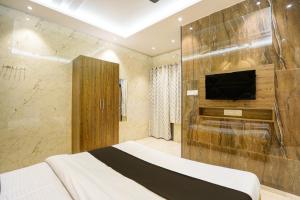 a bedroom with a bed and a television in a room at Hotel O Anand Manglam Hotel & Banquet in Juhi Bari