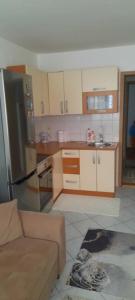 a kitchen with a couch and a refrigerator at Studio apartman City Centre Rogatica in Rogatica