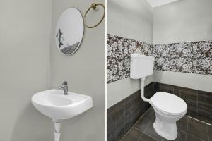 a bathroom with a toilet and a sink and a mirror at Hotel O De Alphabet Home Stays@NTPC in Rāmgundam