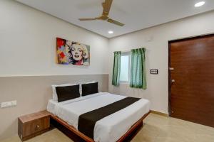 Un dormitorio con una cama y un ventilador de techo. en Hotel O EVA, en Gundipet
