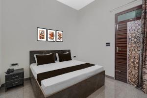 une chambre avec un grand lit et une fenêtre dans l'établissement Hotel O Choudhary Hotel and Resort, à Anūpnagar