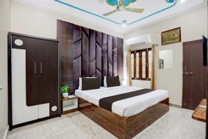 a bedroom with a large bed and a ceiling at Hotel O Kanha Paying Guest House in Varanasi
