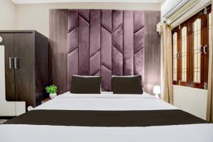 a bedroom with a white bed and a purple wall at Hotel O Kanha Paying Guest House in Varanasi +22 photos