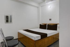 a bedroom with a bed and two chairs at HOTEL O BABA PREM HOTEL in Bihta +21 photos