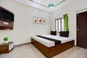 a bedroom with a large bed and a tv at Hotel O Kanha Paying Guest House in Varanasi