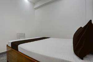 a bedroom with a white bed and a chair at HOTEL O BABA PREM HOTEL in Bihta