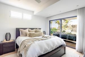 a bedroom with a large bed and a large window at Caves Coastal Escape in Swansea +46 photos