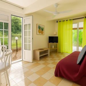 een slaapkamer met een bed en een glazen schuifdeur bij T2 Tropical avec terrasse et jardin in La Trinité