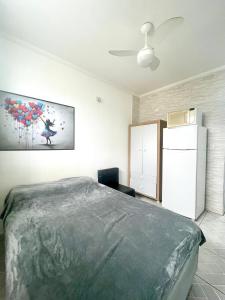 um quarto com uma cama e uma pintura na parede em Brisa dos Sonhos em São Vicente