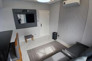 a living room with a couch and a tv at SHB - Apto Aconchegante Família Moderno in Santos