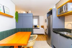 a kitchen with a wooden table and a room with a bed at Studio com 2 Camas de Casal e Garagem - EIX0705 in Curitiba