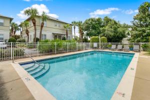 a swimming pool with a fence and trees at Sunnyside #7 by 30A Escapes in Seacrest