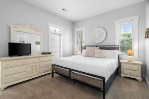 a bedroom with a bed and a flat screen tv at Sunnyside #7 by 30A Escapes in Seacrest +25 photos
