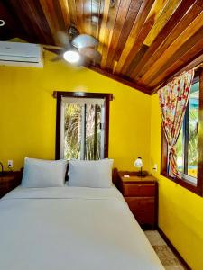 キー・カーカーにあるColinda Cabanasのベッドルーム1室(白いベッド1台付)と黄色い壁