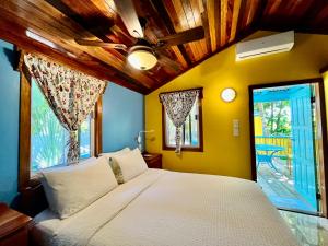 a bedroom with a bed and a large window at Colinda Cabanas in Caye Caulker