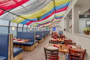 a restaurant with tables and chairs and a colorful ceiling at Clarion Inn Salt Lake City Airport in Salt Lake City