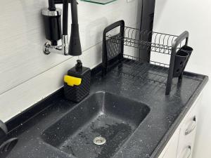 a kitchen counter with a sink in a kitchen at Kitnet vista Mar, pé na areia – Guilhermina in Praia Grande +51 photos