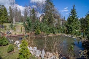 a bridge over a pond in a garden at Apartmán Alex, Nezábudka in Tatranska Strba