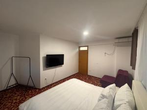 a hotel room with a bed and a flat screen tv at Residence Mahala in Sarajevo