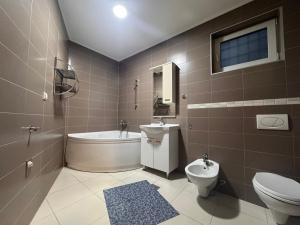 a bathroom with a toilet and a tub and a sink at Residence Mahala in Sarajevo +50 photos