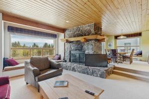 a living room with a stone fireplace and a couch at Beaverhead 1421 in Big Sky