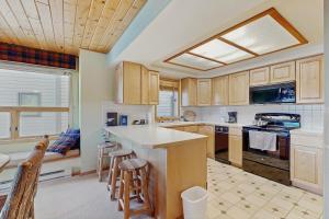 a kitchen with wooden cabinets and a kitchen island with bar stools at Beaverhead 1421 in Big Sky