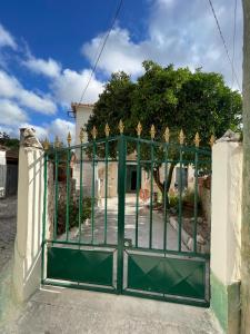 una puerta verde frente a una casa en Orange Tree house, Silver Coast, Alcobaça, Nazaré, en Alpedriz