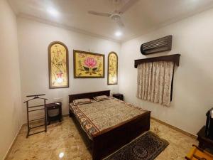 a bedroom with a bed and two pictures on the wall at Sajjan Niwas - A Luxury Homestay in Jodhpur
