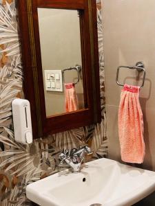 a bathroom with a sink and a mirror and a towel at Sajjan Niwas - A Luxury Homestay in Jodhpur