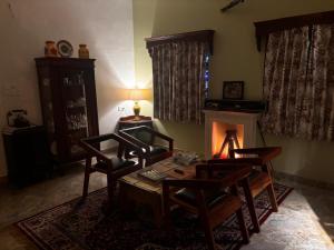 a living room with a table and chairs and a fireplace at Sajjan Niwas - A Luxury Homestay in Jodhpur +27 photos
