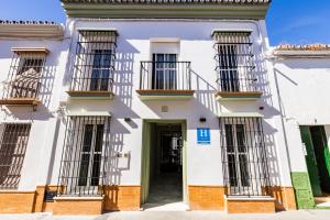 a white building with barred windows and a door at HN Salteras in Salteras